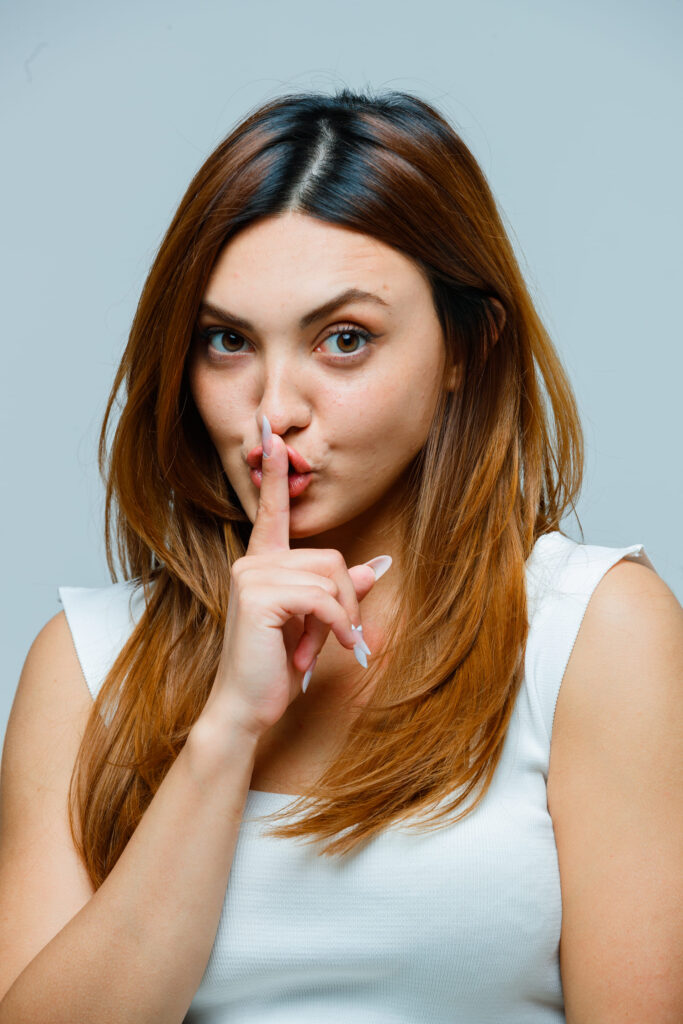 young woman showing silence gesture (1) (1)